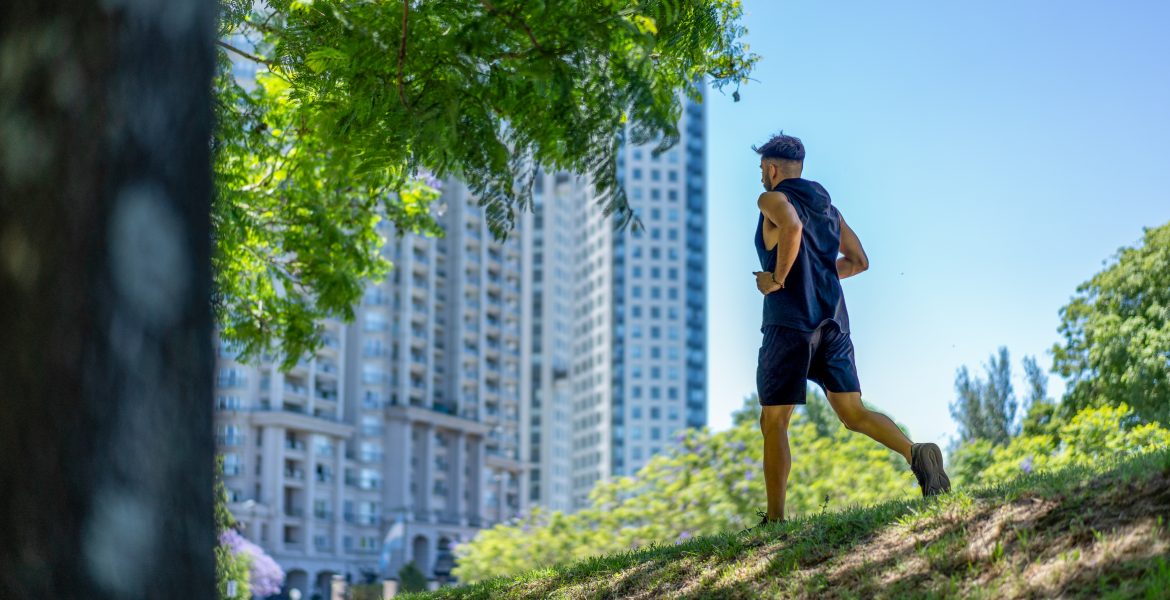 young athletic man running through park downtown chicago