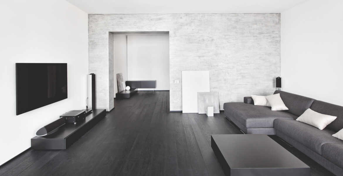 beautiful modern family room with black wood flooring and a soft gray brick wall